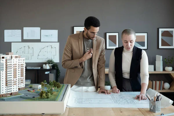Dos elegantes arquitectos o ingenieros discutiendo boceto en plano — Foto de Stock
