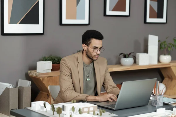 Młody poważny biznesmen w formalwear wpisując na klawiaturze laptopa — Zdjęcie stockowe