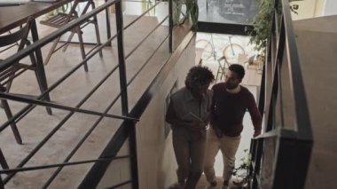 Neşeli siyahi kadın ve çift ırklı erkek sohbetleri, öğleden sonra ilerici şirketlerin ofisinde yürüyüş.