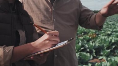 Orta bölüm, tanınmayan çiftçi ve kadın işçinin dışarıda durup planları tartışırken ve notlar alırken görüntülerini çekti.
