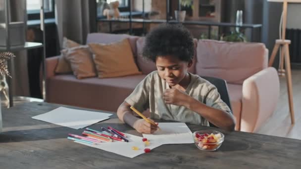 Egy Tízéves Fekete Fiú Mellkasa Aki Otthon Rajzol Asztalnál Édességet — Stock videók