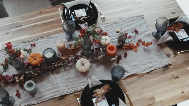家族のお祝いのディナー プレート カトラリー グラス キャンドル 秋の装飾のために設定された木製のダイニングテーブルのトップビュー昼間 — ストック動画