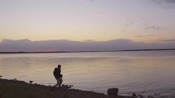 Horizontal Tiro Longo Jovem Passando Noite Lakeshore Jogando Pedra Pulando — Vídeo de Stock