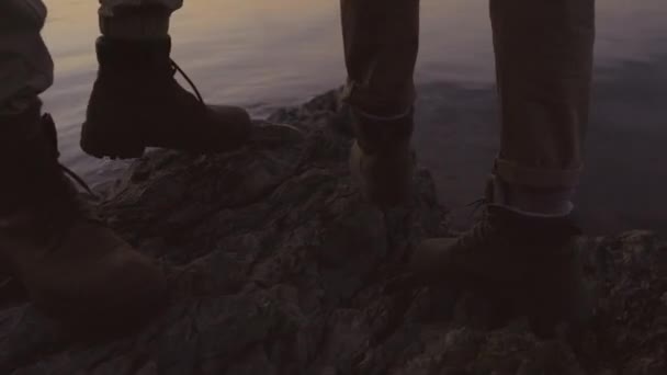 認識できない男と女が崖の上に立って夜の湖を見て — ストック動画
