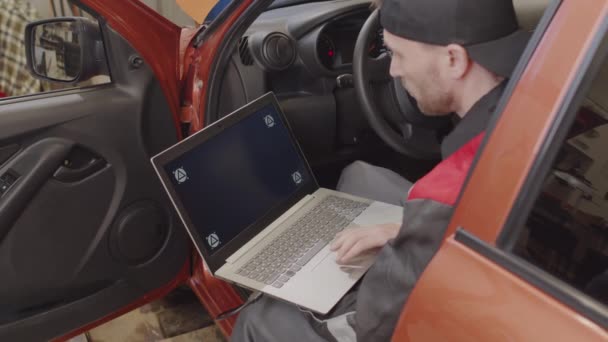 Mechaniker Sitzt Auto Und Macht Diagnosetest Laptop Während Der Autowerkstatt — Stockvideo