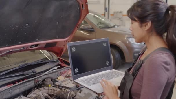 Mecánico Femenino Usando Ordenador Portátil Conectado Por Cable Con Coche — Vídeo de stock