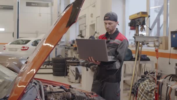 Kaukasische Mechaniker Mit Laptop Auto Mit Kabel Angeschlossen Während Sie — Stockvideo