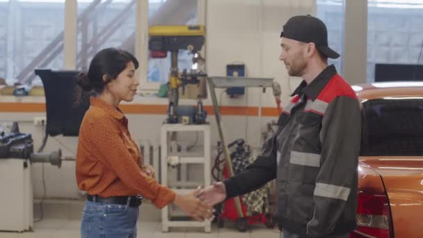 Fröhliche Hispanische Frau Schüttelt Männlichen Automechaniker Die Hand Während Sie — Stockvideo