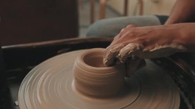 Modern atölyede oturan, çömlek çarkında kil şekillendiren, seramik yapan, sünger kullanan tanınmayan kadın sanatçıların elleri.