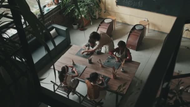 Hochwinkel Von Vier Verschiedenen Kindern Die Der Töpferschule Tisch Sitzen — Stockvideo