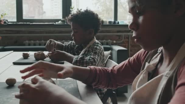 Afrika Kökenli Amerikalı Kız Kardeşinin Çömlekçilik Okulunda Masada Oturup Kil — Stok video