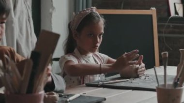 Kil şekillendiren, gündüz seramik kasesi yapan, yandan kesilen Asyalı bir çocuğun sandığı.