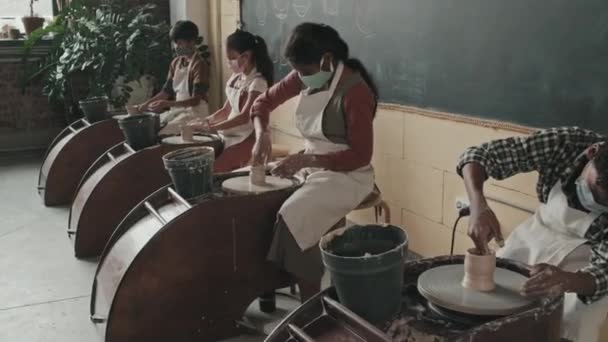 Tracking Diverse Children Wearing Aprons Face Masks Sitting Pottery Wheels — Stock Video