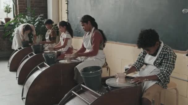 Çok Irklı Dört Çömlekçi Öğrencinin Önlük Giyip Çanak Çömlek Tekerlerinde — Stok video