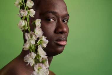 Çiçekle poz veren Afrikalı genç adam
