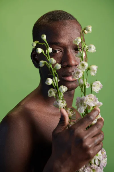 Afrykanin pozujący z liliami — Zdjęcie stockowe