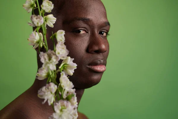 Afrikanischer junger Mann posiert mit Blume — Stockfoto