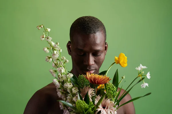 Afrikanischer junger Mann mit Blumenstrauß — Stockfoto