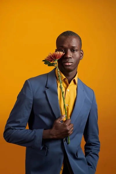 Mężczyzna w garniturze pozował z kwiatem — Zdjęcie stockowe