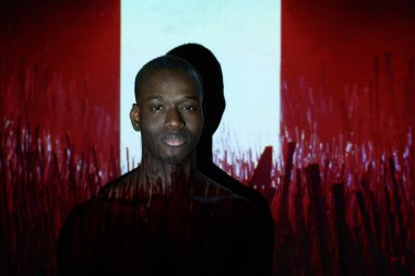Afrikalı adam kırmızı duvara karşı poz veriyor