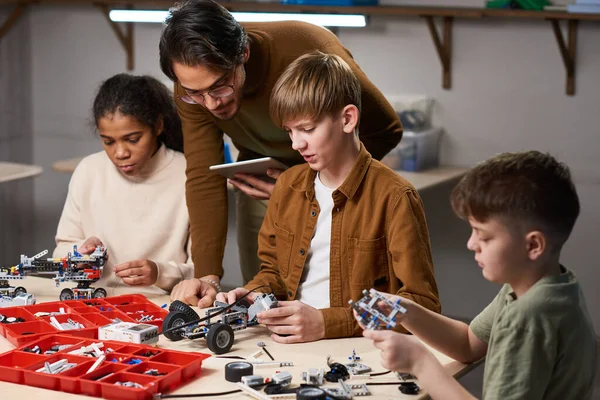 Profesor ayudando a los niños en la clase de robótica —  Fotos de Stock