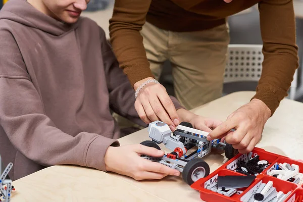 Мальчик-подросток строит робота в классе — стоковое фото