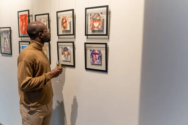Homem olhando para fotos em exposição — Fotografia de Stock