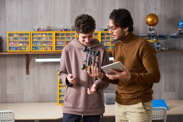 Adolescente projetando robôs com seu professor — Fotografia de Stock