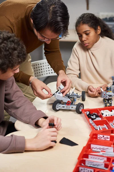 Homme enseignant aux enfants à construire le robot — Photo