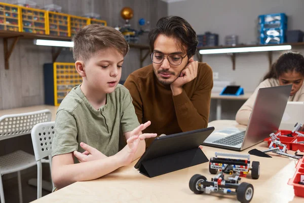 Chlapec ovládající robota z tabletu PC — Stock fotografie