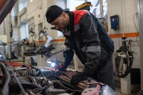 Automécanique contemporain en tenue de travail se penchant sur le capot de voiture ouvert — Photo