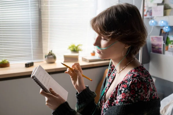 Дівчина-підліток з олівцем дивиться через свої нотатки в блокноті — стокове фото