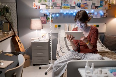 Hastane koğuşunda tablet bilgisayardan konuşan hasta kız.