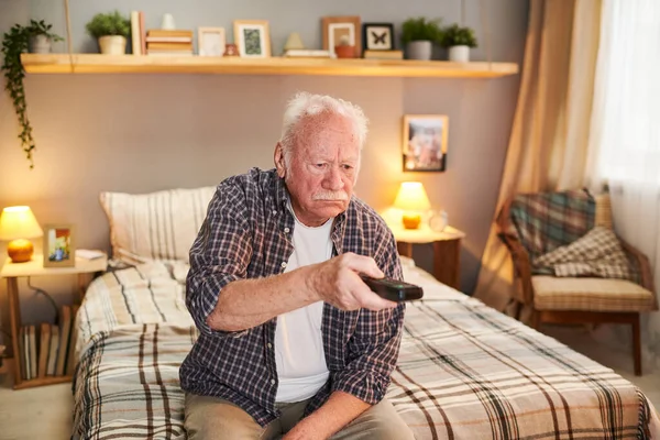 Staruszek ogląda telewizję na emeryturze — Zdjęcie stockowe