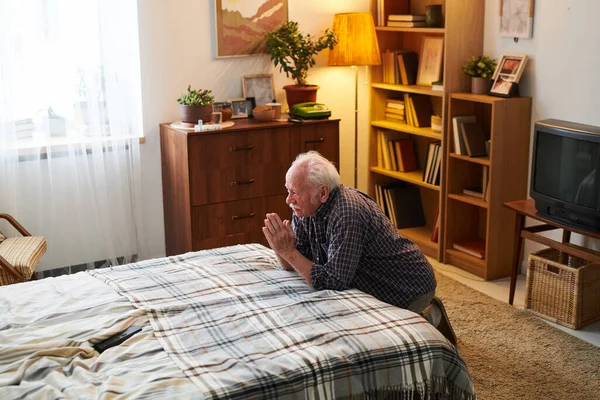 Yaşlı dindar adam yatak odasında dua ediyor. — Stok fotoğraf
