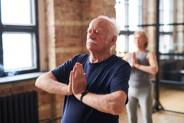 Idősebb férfi meditál jóga órán. — Stock Fotó