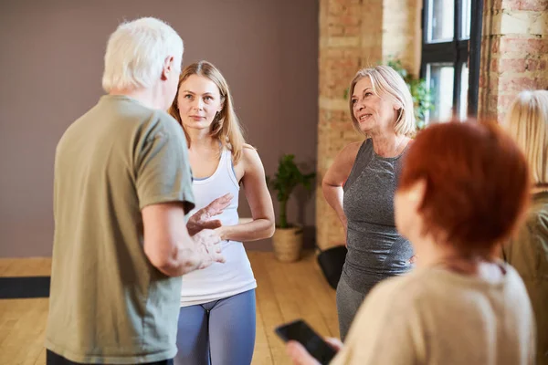 Senioren im Gespräch mit ihrem Fitnesstrainer — Stockfoto