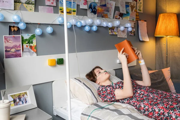 Zieke vrouw leest een boek op ziekenhuisafdeling — Stockfoto