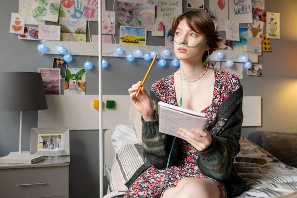 Zieke vrouw schrijft gedachten in haar dagboek — Stockfoto