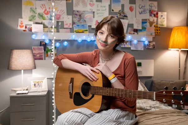 Nemocný dospívající dívka s kytarou sedí v nemocnici oddělení — Stock fotografie