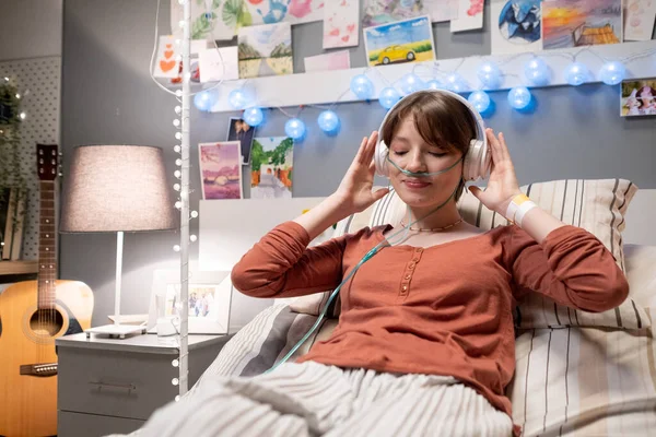 Zieke vrouw maken muzikale therapie tijdens haar behandeling — Stockfoto