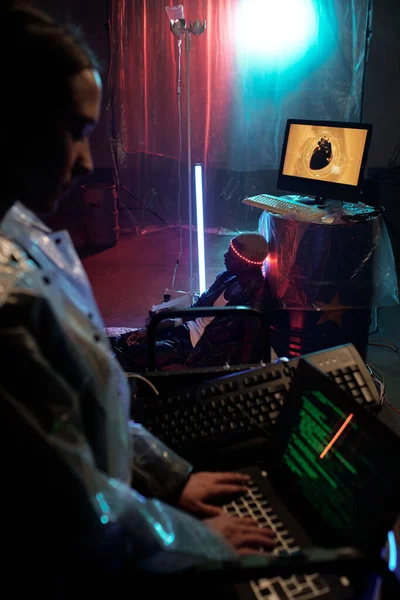 Jeune femme tapant sur ordinateur contre le cyberpunk masculin africain — Photo