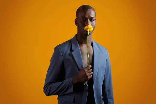 Junger Afrikaner mit gelber Blume am Gesicht — Stockfoto