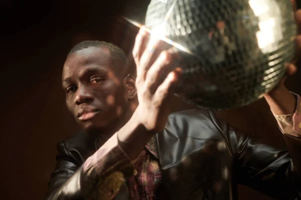 Serious young African man holding discoball and looking at you — Stock Photo, Image