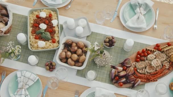 焼き野菜 パスタ サイドディッシュ スナック キャンドル カトラリー グラス ナプキンのテーブル上のトップビュー — ストック動画