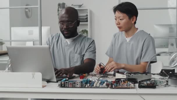 Azji Inżynier Pomocą Multimetru Rozmowy Afroamerykanów Kolega Jak Pracuje Laptopie — Wideo stockowe