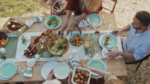 在阳光明媚的夏天 大白鲨家族的成员们坐在木制餐桌旁享用着美味的户外健康食品 享受着丰盛的午餐 — 图库视频影像