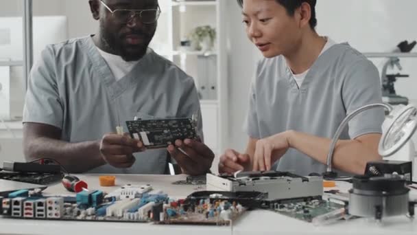 Afrikalı Amerikalı Erkek Mühendisin Asyalı Bayan Meslektaşıyla Bilgisayar Çipini Tartışırken — Stok video
