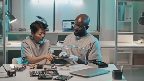 Afro Amerikaanse Mannelijke Ingenieur Bespreken Computer Hardware Met Aziatische Vrouwelijke — Stockvideo