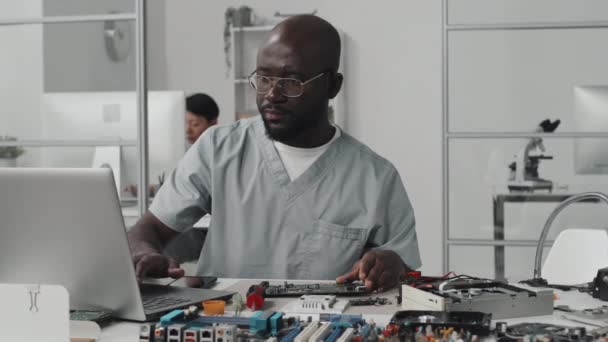 Engenheiro Afro Americano Examinando Placa Circuito Computador Trabalhando Laptop Mesa — Vídeo de Stock